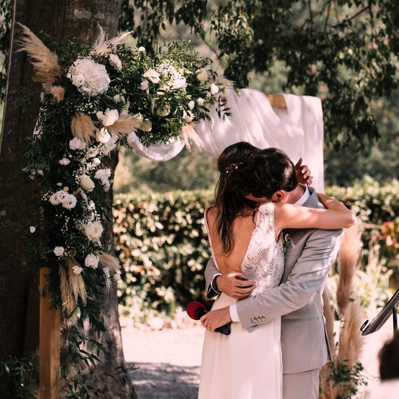 Premier baiser des mariés sous une arche fleurie